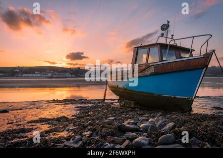 Appledore, North Devon, England. Saturday 3rd April 2021. UK Weather. With sunshine, light cloud and a gentle breeze forecast over the Easter weekend, the sun starts to rise above the rolling hills of North Devon, producing a beautiful sky over the coastal villages of Appledore and Instow. Credit: Terry Mathews/Alamy Live News Stock Photo