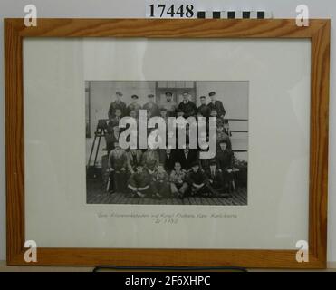 Photography.Black and white photograi in glass and frame, depicting group image of thirty three men dressed in work clothes.The picture is taken outside a white building, probably the filor workshop.The photograph measures 170x225 mm, is attached to white paper.To the right typed text with data on men's name and smoke and rise name (1965) .Text during photo: 'Upper Filorverkstaden at the King. The navy lap Karlskrona in 1930'.The name of the persons, see inventory attachment.The frame of Betsed Fur, B = 25 mm, the back dressed with Masonite.1930 - 1930. Stock Photo