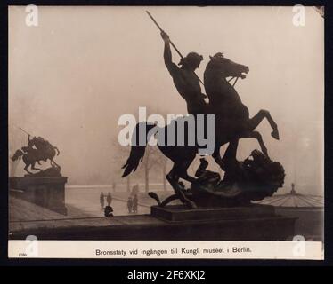 The picture shows a bronze sculpture that adorns the free staircase of Altes Museum in Berlin.The statue shows a fighting warrior to horse fighting against a lion .. The picture shows a bronze sculpture that adorns fryspegan of Altes Museum in Berlin.The statue shows a fighting warrior to horse fighting against a lion. Stock Photo