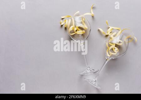 Two glasses on with yellow ribbons on a gray background - The concept of a birthday or anniversary celebration - A place for text to congratulate a lo Stock Photo