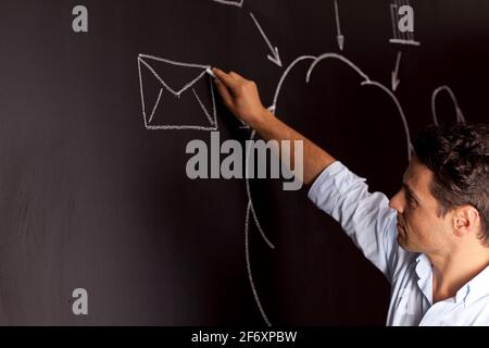 Businessman writing a cloud computing diagram on the chalkboard Stock Photo