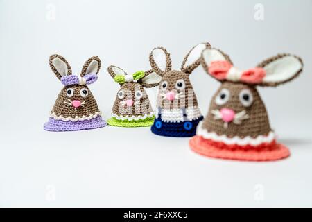 Homemade amigurumi egg warmers crocheted from wool. In different scenes with a white and gray background and on a dining tabl Stock Photo