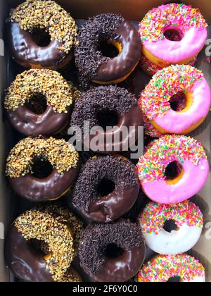 Assorted doughnuts in a vertical row close up Stock Photo - Alamy