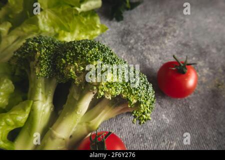 Broccoli and tomatoes on gray background Stock Photo