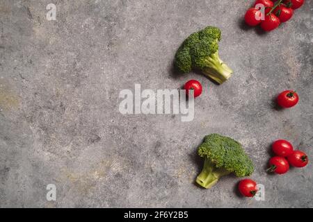 Broccoli and tomatoes on gray background Stock Photo
