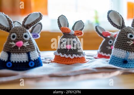 Homemade amigurumi egg warmers crocheted from wool. In different scenes with a white and gray background and on a dining tabl Stock Photo