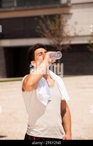 Tired athlete refreshing him self with fresh water Stock Photo