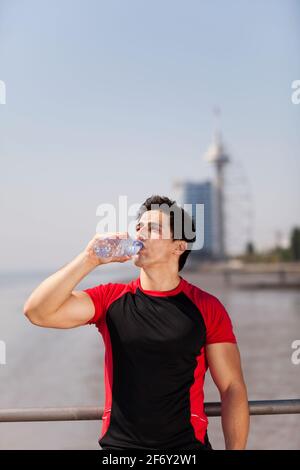 Tired athlete refreshing him self with fresh water Stock Photo