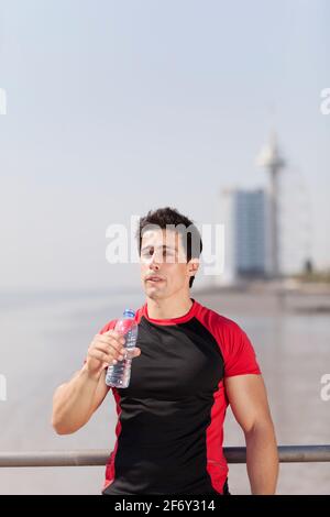 Tired athlete refreshing him self with fresh water Stock Photo