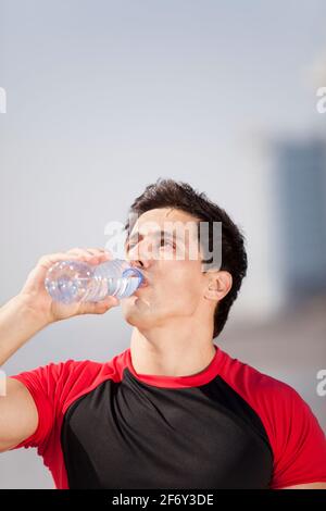 Tired athlete refreshing him self with fresh water Stock Photo