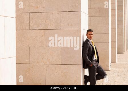 Sad businessman next to some wall looking down Stock Photo