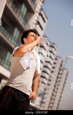 Tired athlete refreshing him self with fresh water Stock Photo