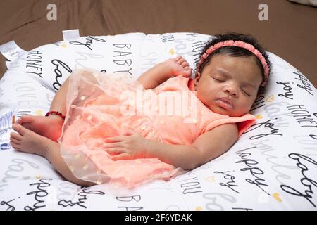 Newborn baby girl 3 weeks old lying on back asleep Stock Photo