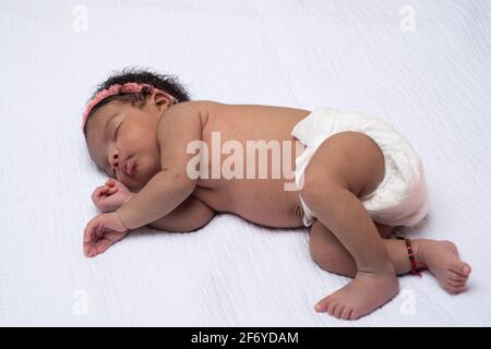 Newborn baby girl 3 weeks old, sleeping on side, full length Stock Photo