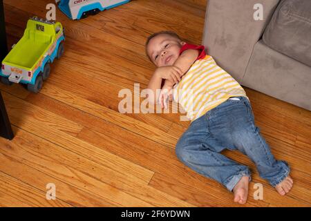 2 year old boy, tired, lying on floor, crying, tantrum Stock Photo