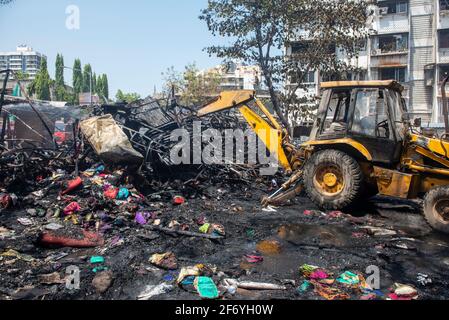 Mumbai , India - 30 March 2021, Wheeled Excavators working on a burnt rubble and twisted metal from fire at Goregaon West in Mumbai Maharashtra India Stock Photo