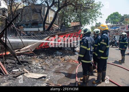 Mumbai , India - 30 March 2021, The group of firefighters man are inject spray the water to fire accident on cloth shops in Goregaon West Mumbai Mahar Stock Photo