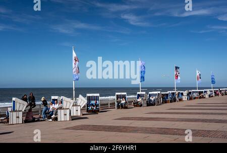 03 April 2021, Schleswig-Holstein, Westerland/Sylt: People sit on the beach promenade in Westerland on Holy Saturday. Photo: Axel Heimken/dpa Stock Photo