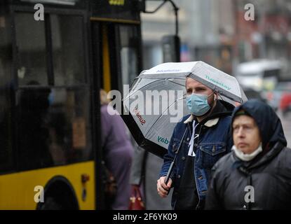 Kiev, Ukraine. 02nd Apr, 2021. A man holds an umbrella while wearing a mask as a preventive measure against the spread of covid-19 stands at a bus stop. In Ukraine, as of the morning of April 3, 20,341 new cases of COVID-19 infection were confirmed, which is another record for the number of cases per day. The largest number of confirmed cases over the past day was registered in Kiev, as well as in Lviv, Odessa, Kharkov and Dnepropetrovsk regions. (Photo by Sergei Chuzavkov/SOPA Images/Sipa USA) Credit: Sipa USA/Ģ����ý Live News Stock Photo