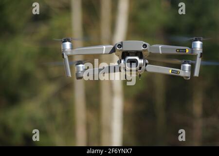 Camera drone in flight before a forest background Stock Photo