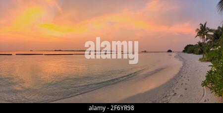 Panorama View of Beautiful Sunset Sky in Maldives. Sandy Beach with Colorful Sky and Laccadive Sea on Maldivian Island. Stock Photo