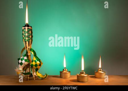 Conceptual traditional Malay torch and lamp and decorative ketupat during Hari Raya Aidilfitri celebration
