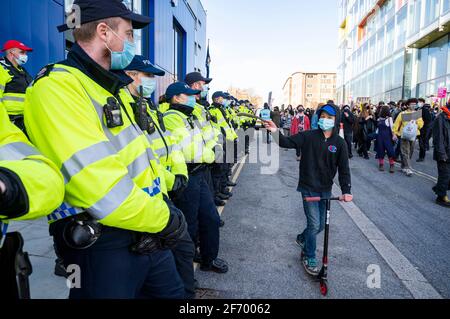 Brighton UK 3rd April 2021 - A youngster on a scooter passes by the police station as hundreds of 'Kill The Bill' protesters march through Brighton in protest against the governments controversial new bill which would give police powers to crack down on peaceful protest  :  Credit Simon Dack / Alamy Live News