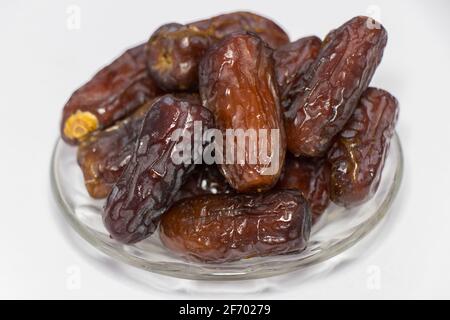 Dried dates fruit isolated on white background. Photo of Medina dates in a small plate. Stock Photo