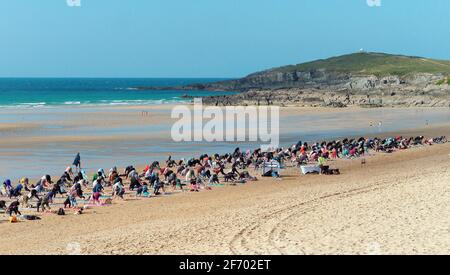 Newquay, Cornwall, England, 3rd  April 2021. UK weather: Cool with sunshine for a mass Yoga class involving 300 plus participants. Silent disco yoga organised by Anthony Durkin DJ in combination with Oceanflow yoga. Fistral beach. Credit: Robert Taylor/Alamy Live News� Stock Photo