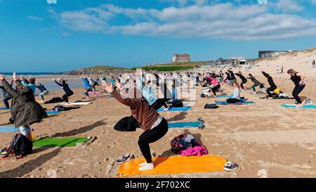 Newquay, Cornwall, England, 3rd  April 2021. UK weather: Cool with sunshine for a mass Yoga class involving 300 plus participants. Silent disco yoga organised by Anthony Durkin DJ in combination with Oceanflow yoga. Fistral beach. Credit: Robert Taylor/Alamy Live News� Stock Photo