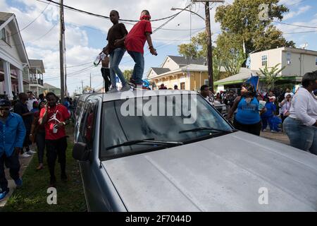 Kids dancing on cars during Prince of Wales, New Orleans Social Aid and Pleasure Club Second Line (Secondline) Second Line Sunday parade, New Orleans. Stock Photo