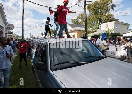 Kids dancing on cars during Prince of Wales, New Orleans Social Aid and Pleasure Club Second Line (Secondline) Second Line Sunday parade, New Orleans. Stock Photo