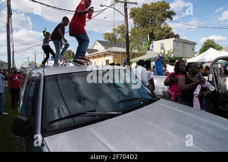 Kids dancing on cars during Prince of Wales, New Orleans Social Aid and Pleasure Club Second Line (Secondline) Second Line Sunday parade, New Orleans. Stock Photo