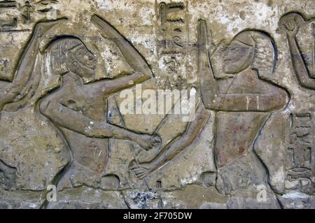 Hieroglyphic carving from the wall of the Temple of Medinet Habu on the West Bank of the Nile at Luxor. Showing two men fighting using a form of karat Stock Photo