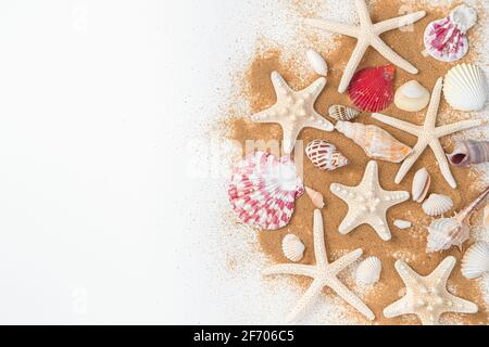 Starfish and various beautiful shells on the beach sand on a light background. Top view, copy space. The concept of a beach holiday. Stock Photo