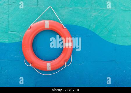 Lifebuoy hanging on a colorful wall Stock Photo