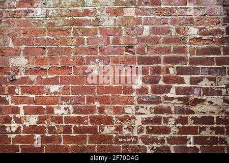 Weathered old wall with red bricks. Stock Photo