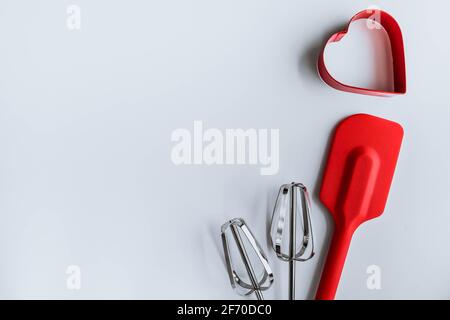 Baking supplies on white. Spatula, mixer whisks, cookie cutter on white background Stock Photo