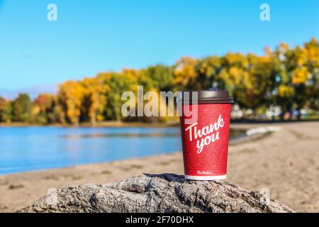 Red Paper Tim Hortons cup of coffee with Thank You words on natural morning background Stock Photo