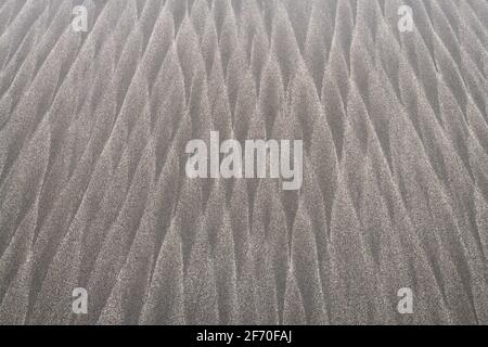 Windblown sand on an Oregon Coast beach blown to form the repeating natural design of stacked pencils Stock Photo