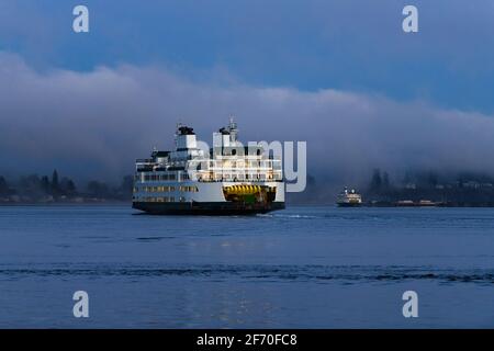 Pair of Washington State Ferries on a foggy morning crossing Puget Sound in Western Washington State in dawn light Stock Photo