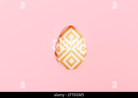 One colored Easter egg on pink paper, top view Stock Photo