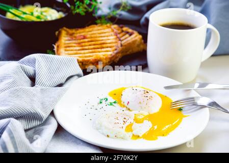 Morning poached eggs with a roasted sandwich and a cup of coffee Stock Photo