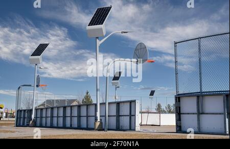 Solar powered street lights recharge in the daylight at an outdoor recreation court in Airdrie Alberta Canada. Stock Photo