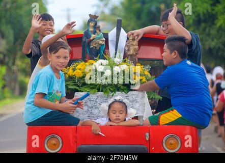 Float on the back of a pickup with children and images of saints for the May celebrations of Flores de Mayo... the children offer flowers before the image of the Virgin Mary as a symbol of love, affection and veneration. Near Toledo City, Central Visayas, Cebu, Philippines. Stock Photo