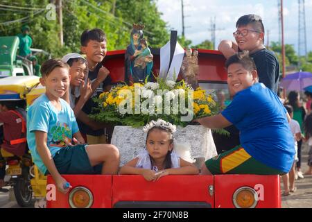 Float on the back of a pickup with children and images of saints for the May celebrations of Flores de Mayo... the children offer flowers before the image of the Virgin Mary as a symbol of love, affection and veneration. Near Toledo City, Central Visayas, Cebu, Philippines. Stock Photo