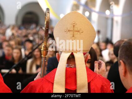 The bishop grants the Sacrament of Confirmation in a large Christian Church Stock Photo