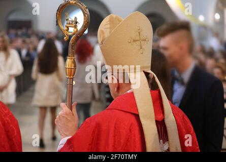 The bishop grants the Sacrament of Confirmation in a large Christian Church Stock Photo