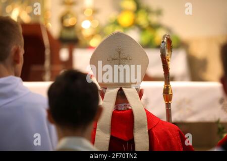 The bishop grants the Sacrament of Confirmation in a large Christian Church Stock Photo