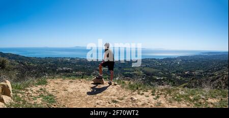 Hiker admiring view from Old Romero Canyon Trail in Montecito, California near Santa Barbara on a clear, sunny spring day Stock Photo